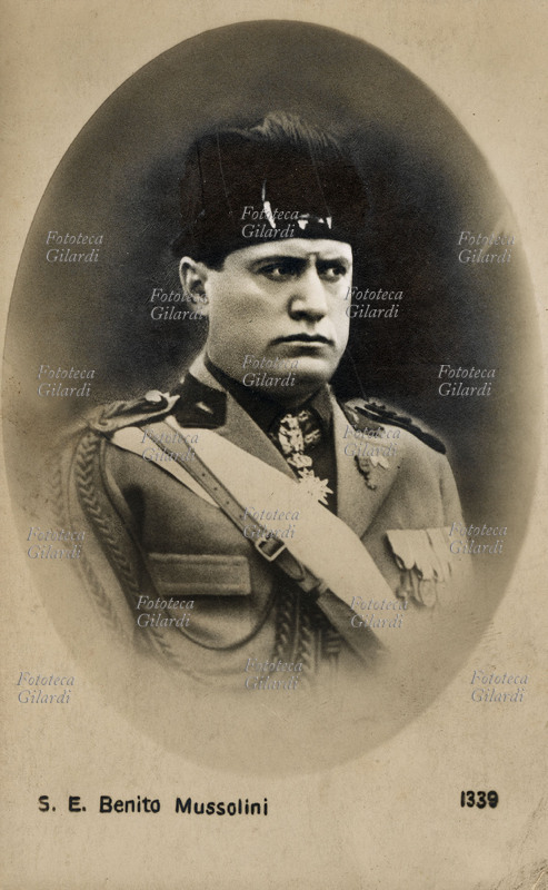 Benito MUSSOLINI (1883-1945) ritratto del duce in alta uniforme, decorata con numerose medaglie al petto e la croce di cavaliere al colletto; come copricapo il fez, dettaglio originale della divisa fascista. Fotografia in ovale, Ballerini & Fratini, Firenze 1935 circa.