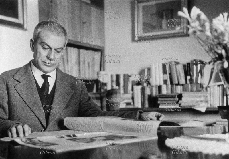 Elio VITTORINI (1908-1966) scrittore, ritratto nel suo studio mentre legge un quotidiano, 1960 circa.