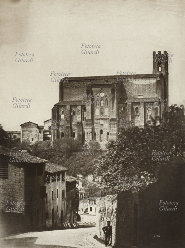 SIENA La Basilica Cateriniana di San Domenico vista da via Fontebranda; un uomo in cilindro sta pigramente appoggiato al muro. Fotografia, Italia 1855 circa.