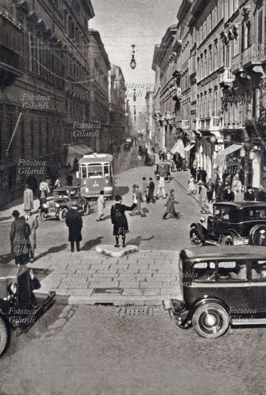 ROMA Affollata scena di strada in Via del Corso a Roma: un vigile dirige il traffico tra automobili, pedoni e tramvai, 1933 circa