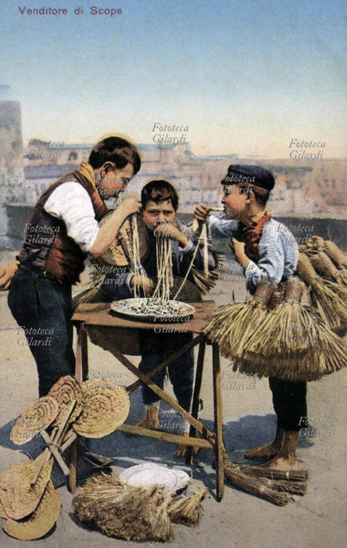 MESTIERI Piccoli venditori ambulanti di scope mangiano i maccheroni. Cartolina postale, 1900 circa
