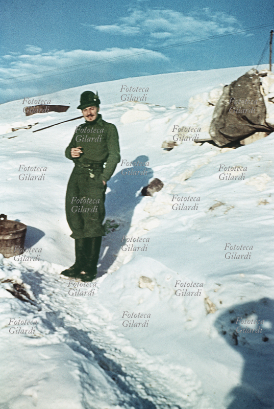 SECONDA GUERRA MONDIALE Ritratto a figura intera del tenente alpino Roberto Cacchi (1914-2004) davanti al rifugio sotto la neve. Il tenente, autore di rare testimonianze fotografiche a colori della tragica spedizione in Russia, aveva chiesto all\