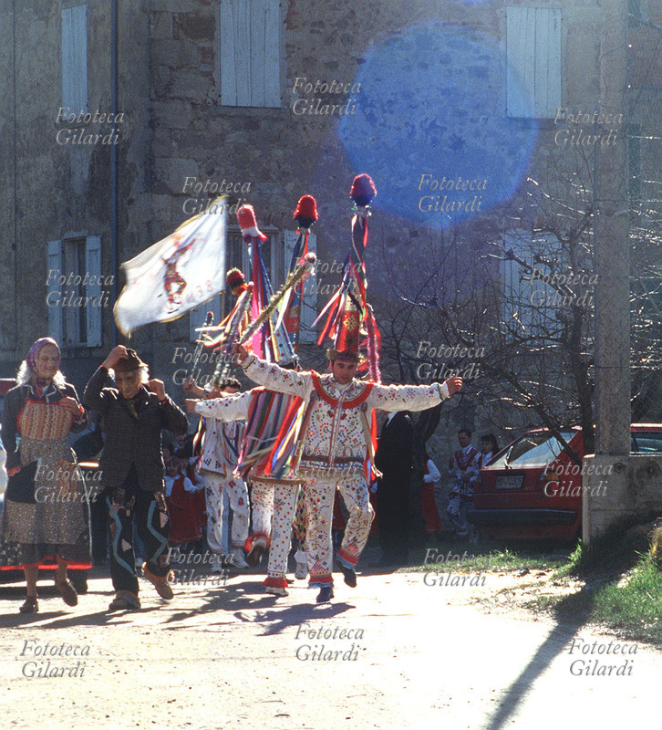 CARNEVALE di Benedello, gli Arlecchini sfilano per il paese insieme a maschere da vecchio. Appennino modenese. Fotografia di Elena Piccini, Pavullo nel Frignano (Modena) 1995.