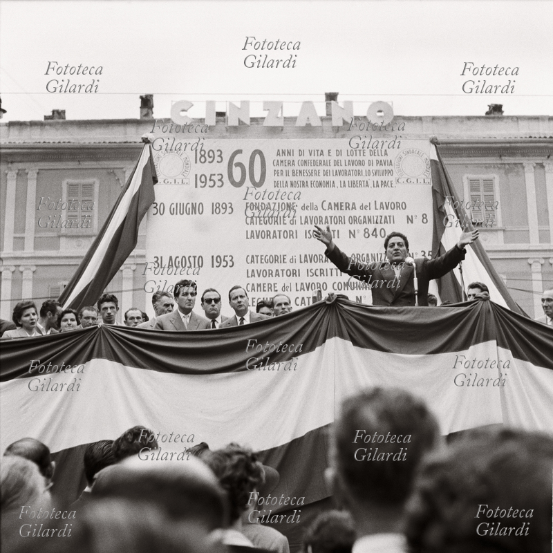 STORIA DEL MOVIMENTO OPERAIO cerimonia per il 60° anniversario della fondazione della Camera del Lavoro di Pavia. Discorso di Giuseppe Di Vittorio (1892 - 1957) davanti alla sede della CdL, dietro al palco il tabellone \