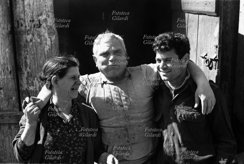 Calabrian FAMILY. Outside a shack in Montecatini, father, mother and son, still in workers\