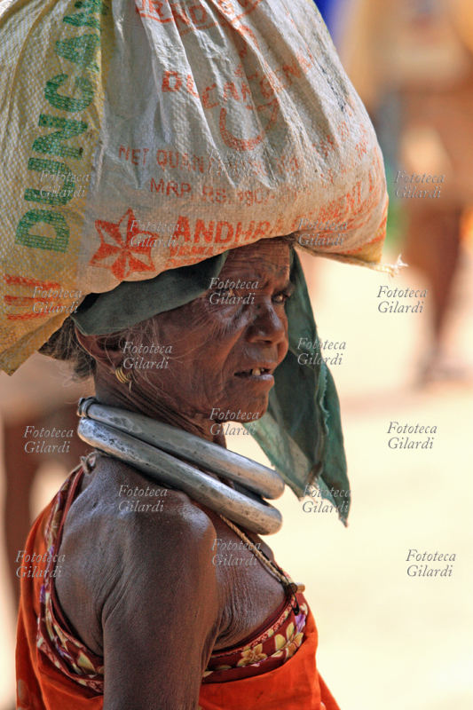INDIA Donna indigena trasporta un carico sulla testa, Orissa 2010