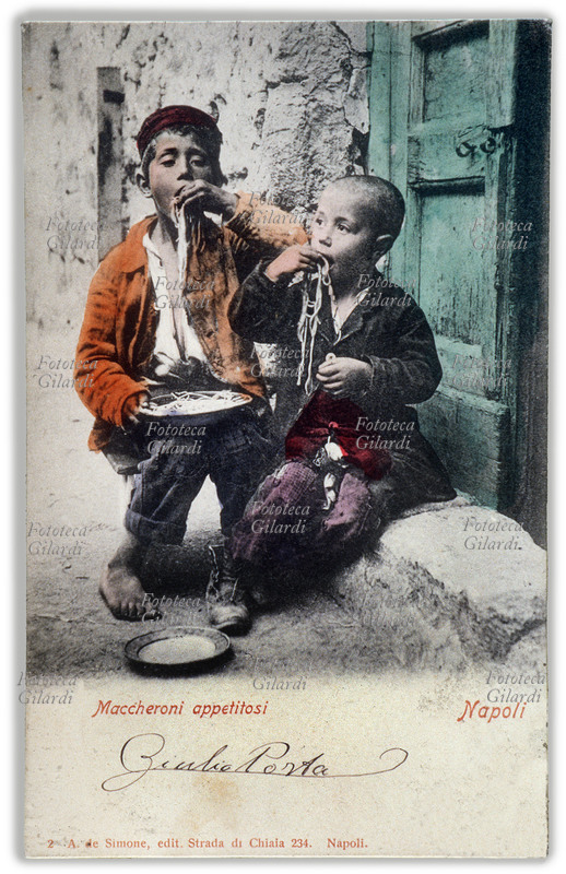 MACCHERONI APPETITOSI Due scugnizzi napoletani mangiano spaghetti con le mani, seduti in strada. Cartolina postale inizio del XX secolo