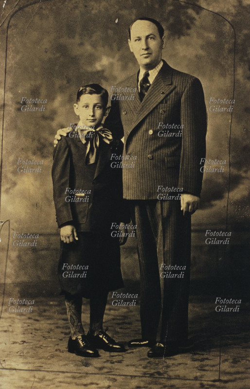 FAMIGLIA padre e figlio, entrambi elegantissimi. Il bambino indossa un completo con pantaloni \