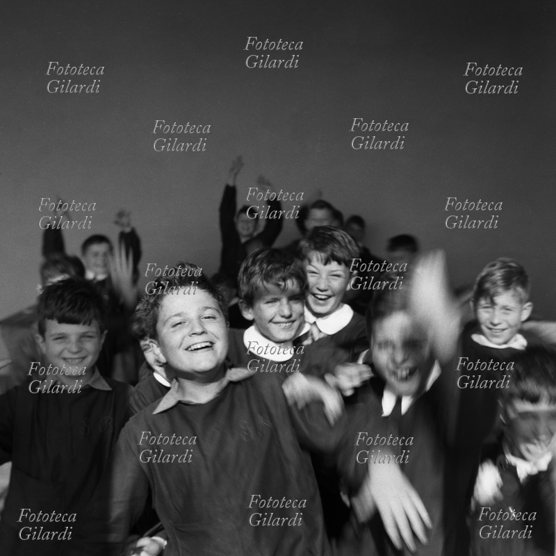 SCUOLA alunni di una scuola elementare fiorentina, in gran parte frequentata da figli delle maestranze della Pignone, vanno vivacemente incontro al fotografo al suono della campanella della ricreazione. Il loro avvenire di studenti è legato al mantenimento del posto di lavoro dei genitori, minacciato dalla messa in liquidazione dello stabilimento da parte della proprietaria SNIA Viscosa. Fotografia di Ando Gilardi (1921 - 2012), #andogilardi pubblicata in \