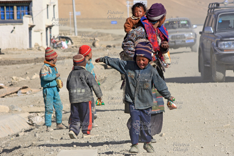 TIBET Villaggio di Tingri, bambini con la madre camminano sul ciglio della strada impolverata, maggio 2009
