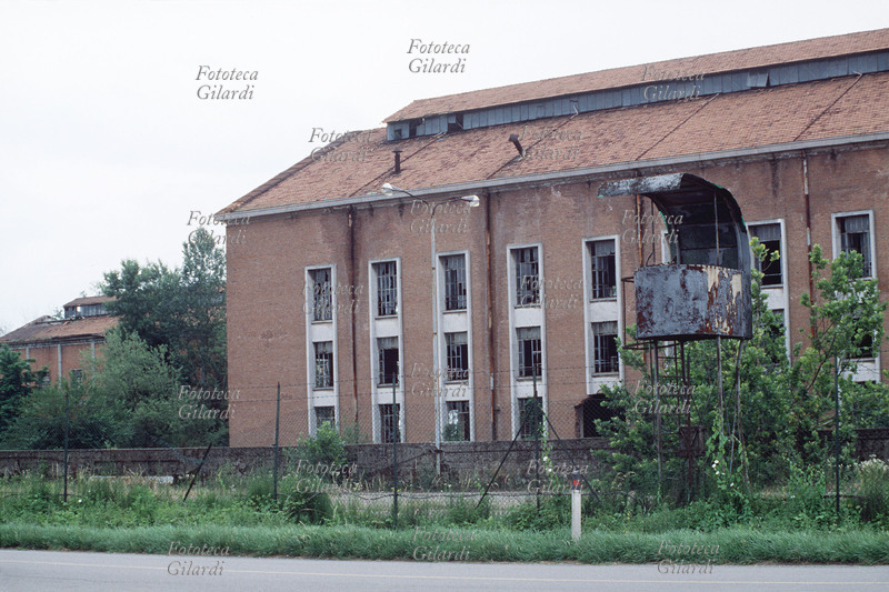 II G.M. ITALIA ex campo di prigionia e concentramento allestito durante la occupazione tedesca e la repubblica di Salò in una fabbrica di zuccheri abbandonata nei pressi di Alessandria. Si nota una torre di guardia per la sorveglianza sul campo. Fotografia di Patrizia Piccini, Alessandria 1992