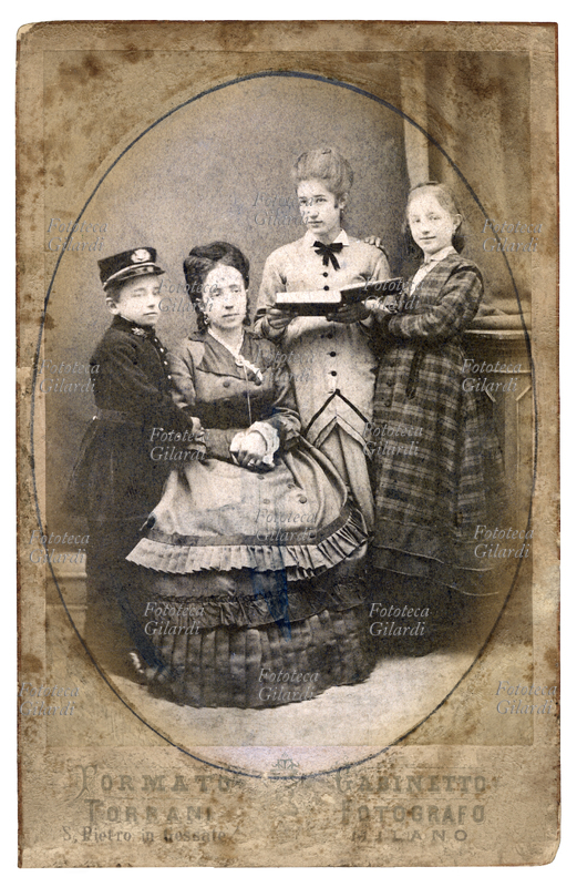 FAMIGLIA - Gruppo di famiglia con una mamma ed i suoi tre figli: due ragazze, una delle quali è ritratta con un libro in mano, ed un bambino, ritratto in piedi alla destra della mamma. Italia,1900 circa