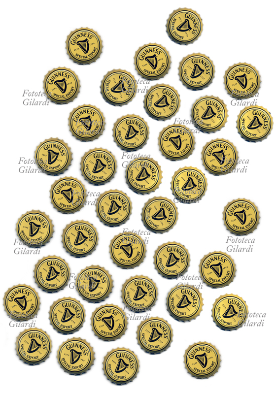 TAPPO A CORONA, capsule metalliche di chiusura per bottiglia o bottiglietta di vetro della celebre birra Guinness, scansionati in scala 1:1 su fondo bianco. La Guinness è una famosa birra di tipo stout o di tipo porter commercializzata in tutto il mondo, prodotta dalla Arthur Guinness Son & Co., fabbrica di birra irlandese fondata a Dublino nel 1759 da Arthur Guinness. Questi tappi appartengono alla produzione per l\