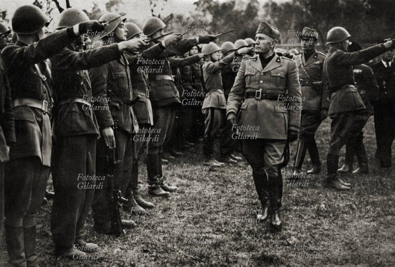 REPUBLIC OF SALÒ Benito Mussolini, head of RSI (Repubblica Sociale Italiana) browsing a department legions of the National Guard before delivery of the battle flag. The military salute with the dagger as a sign of attack. (present arms) Gargnano October 28, 1944