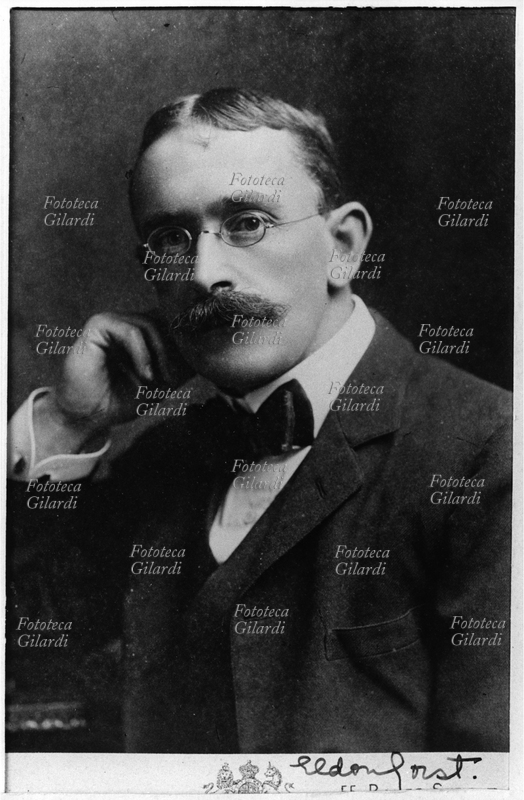 Sir John Eldon GORST (1861-1911) agente diplomatico coloniale inglese. Nato in Nuova Zelanda dove il padre svolgeva funzioni di intermediario fra i maori e il governo britannico, fu però allevato a Londra; terminati gli studi da avvocato fu inviato in Egitto con la mansione di controllore delle tasse dirette; qui intraprese una rapida carriera, che portò alla nomina a Console Generale nel 1907. Colpito dal cancro, rientrò in patria negli ultimi mesi della sua vita. Ritratto con autografo dal fondo \