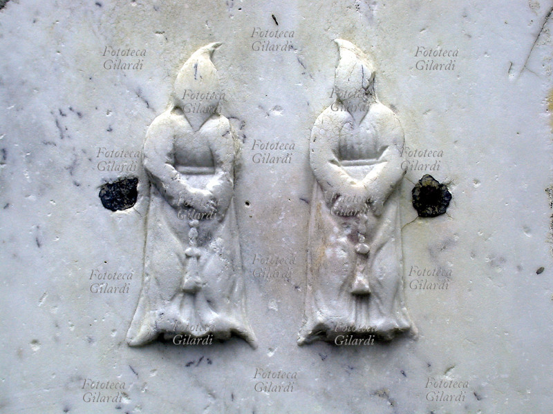 CONFRATERNITE Due membri di una confraternita con il saio incappucciato. Rapallo, rilievo in marmo, XVI secolo.