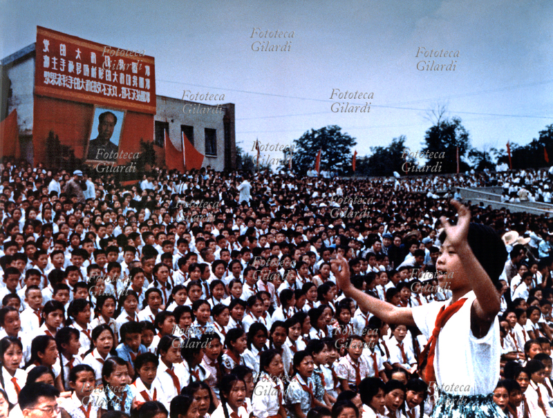 CINA Le peonie di Mao intonano inni esortate da un grande ritratto del Presidente, immagine ufficiale creata e diffusa per propaganda politica. Commemorazione del 1° Maggio, Pechino 1967
