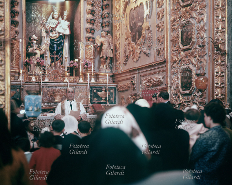 CHURCH Photographic view of the interior of a church during the celebration of a Mass. The Priest addresses the faithful head-on, it is one of the first religious functions celebrated in Italian after the Second Vatican Council abolished the Latin rite in which the celebrant had his back to the people, accompanied by Gregorian chants, and Communion was received on his knees . Photograph by Ando Gilardi (1921-2012) #andogilardi, Italy circa 1967.