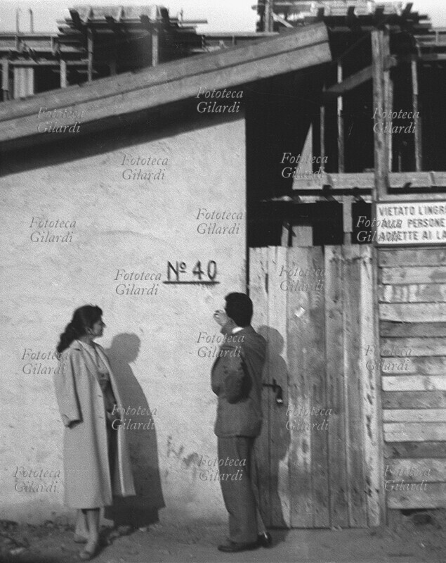BOOM ECONOMICO Fotografia ricordo di una giovane coppia di fidanzati che sogna il proprio futuro di famiglia amorevole e serena mentre visita il cantiere del condominio in costruzione al civico 40 di via Maffucci. Si sposeranno quando il loro appartamento, acquistato su progetto dal costruttore prima dell\