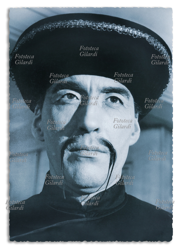 CINEMA Cartolina pubblicitaria con ritratto di Christopher Lee (27 maggio 1922 – 7 giugno 2015), nei panni del diabolico dottor Fu Manchu in una serie di cinque film prodotti da Harry Alan Towers. Ideato dallo scrittore britannico Sax Rohmer (pseudonimo di Arthur Sarsfield Ward, 15 febbraio 1883 – 1º giugno 1959), Fu Manchu rappresenta il prototipo del genio del male, il nemico giurato del mondo occidentale, la personificazione del "pericolo giallo". Produzione internazionale Gran Bretagna, Spagna, Germania, USA, sviluppata fra il 1965 e il 1968.
