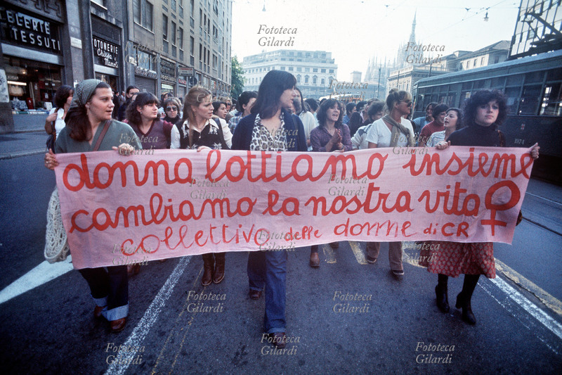 FEMMINISMO Donna, manifestazione femminista sfila in una strada del centro, sullo sfondo il Duomo. Lo slogan: \