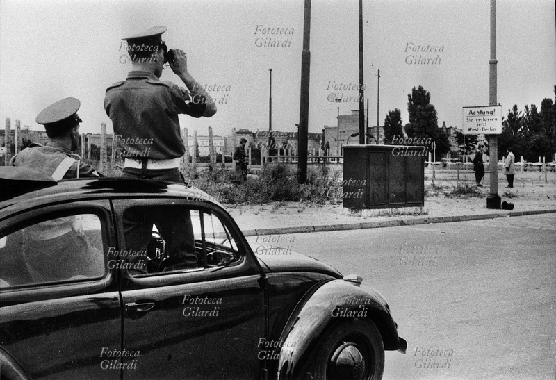 MURO DI BERLINO dalla zona est bloccata la polizia inglese osserva con il binocolo . Germania, agosto 1961