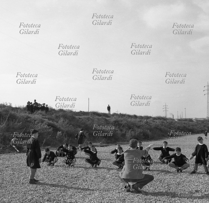 SCUOLA Alunni della scuola elementare fanno ginnastica in cortile con il maestro, mentre un gruppetto di un\