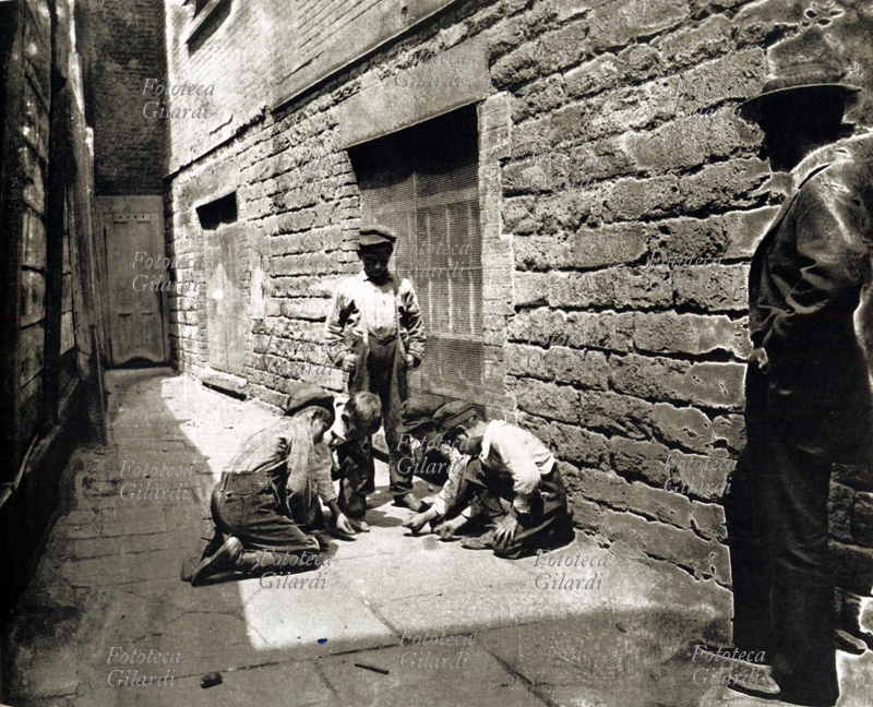 BAMBINI Gruppo di bambini giocano in strada in un quartiere popolare di New York. Fotografia di Jacob A. Riis, New York 1900 - 1930