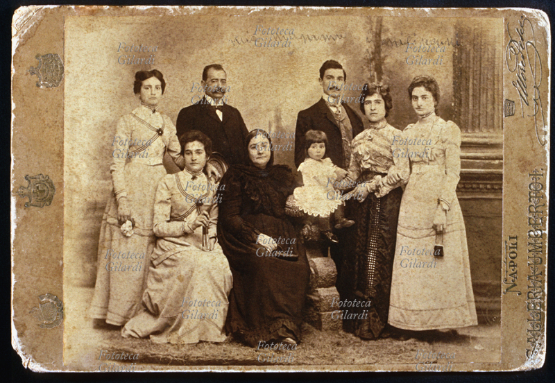 FAMIGLIA Seduta al centro la madre (vestita a lutto) con accanto una delle figlie. In piedi a sin. un\