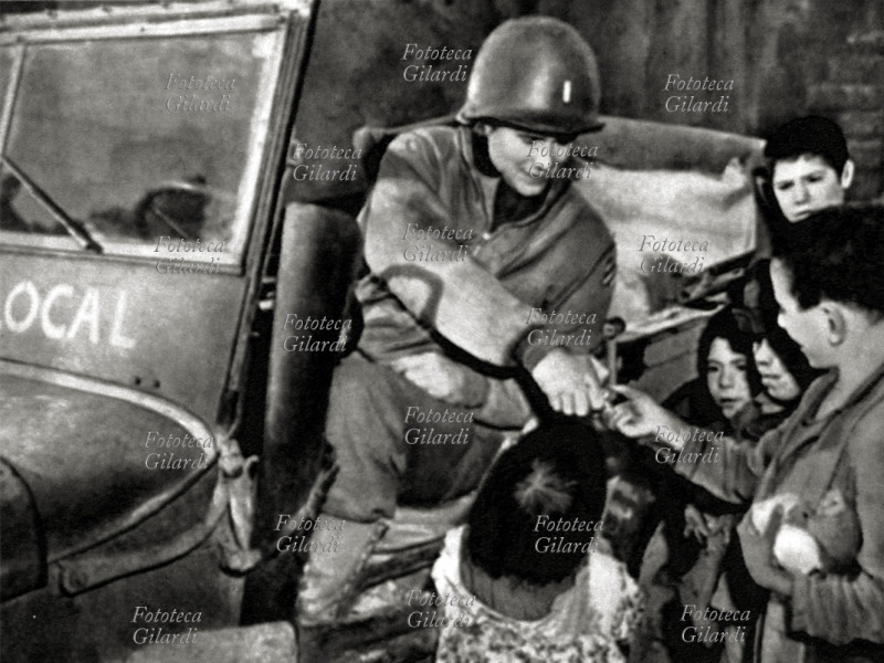 LIBERAZIONE Gli alleati liberano la città occupata dai tedeschi, un soldato americano distribuisce cioccolato ai bambini. Roma giugno 1944.