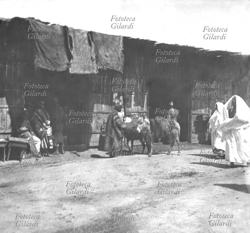 JAFFA In front of the shops, with the merchants, some customers and the beasts of burden (donkeys) stop. Photographic view, Ottoman Empire, around 1900.