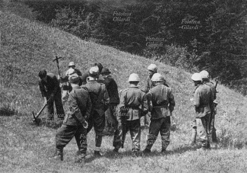 JUGOSLAVIA Territorio di Cerknica, nella provincia italiana di Lubiana sul confine italo-jugoslavo: prima della fucilazione di ostaggi civili effettuata da militari italiani, le vittime si scavano la fossa. Quattro uomini usano i badili sotto il tiro di alcuni militari armati che li circondano e controllano il lavoro. Sequenza di fotografia spontanea (vedi anche #16039, #17827), Slovenia, luglio 1942