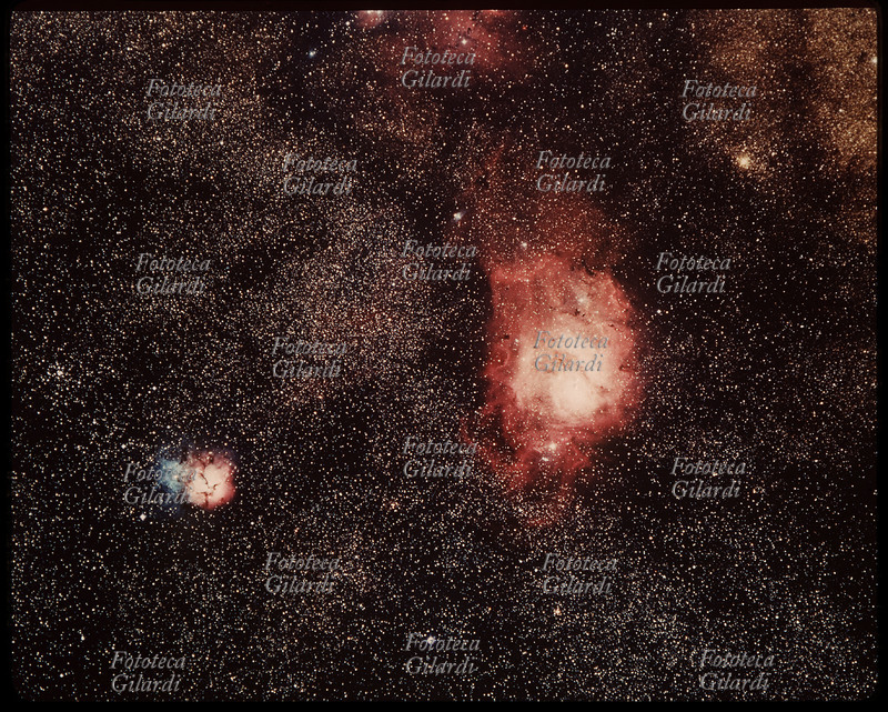 ASTRONOMIA Fotografia astronomica, nebulosa Trifida del Sagittario. La nebulosa contiene delle macchie scure chiamate \