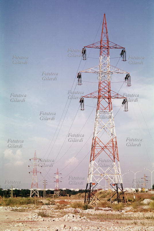ELECTRICITY High voltage pylons carry the electrical cables that bring electricity from power plants to large population centres. Photograph by Ando Gilardi (1921-2012) #andogilardi, Italy circa 1975.