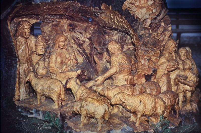 PRESEPIO artigianale intagliato in un tronco di pino. Dettaglio della Sacra Famiglia e della adorazione dei pastori. Fotografia di Elena Piccini. San Michele all\