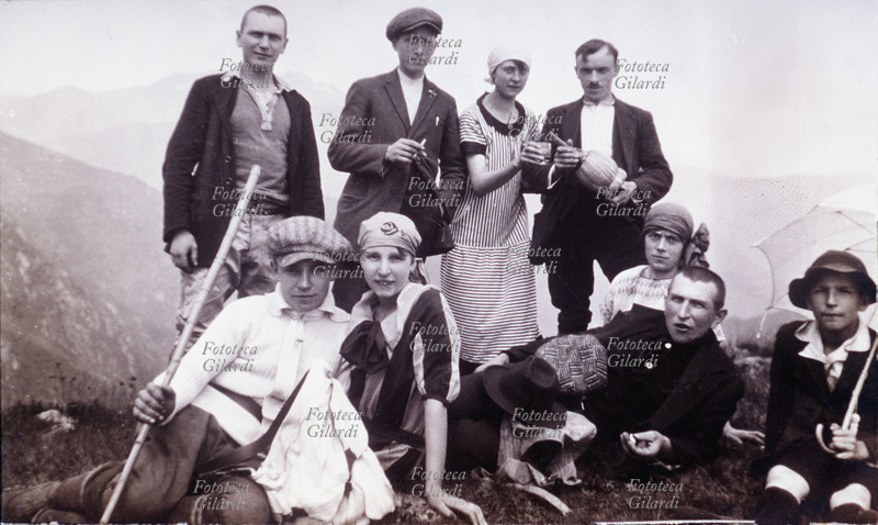 TOURISM Group of boys in trip in mountain. In the moment of it pauses besides to rest itself, it is drunk a toast and it is put down for the photo-memory. Italy, 1920 approximately.