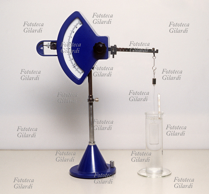 BILANCIA idrostatica Orma-West. Rapida determinazione del peso specifico dei liquidi, con lettura del quadrante della terza cifra decimale ed approssimazione della quarta. Romano scorrevole a manopola frontale di azzeramento. Cilindro di vetro galleggiante di Reimann da 5cc. Fotografia, 1994 circa