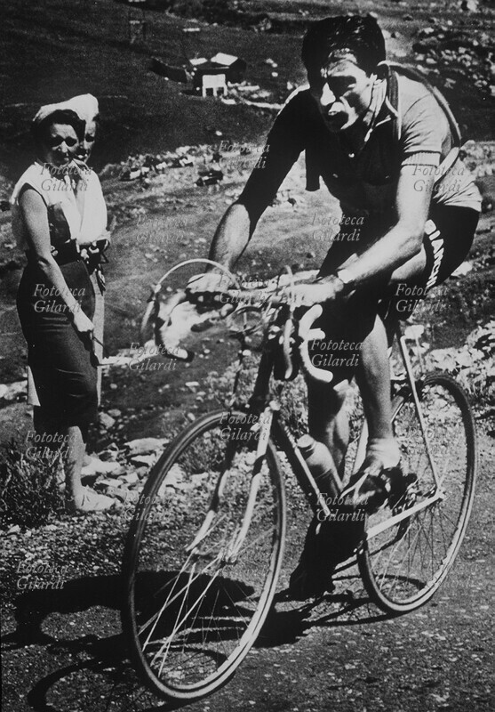 SPORT CICLISMO Fausto Coppi (15 settembre 1919 – 2 gennaio 1960) impegnato in una dura salita su sterrato. Cartolina postale spedita da lui medesimo a Martina Perinetto il 24 settembre 1951. Fotografia di anonimo, Torino 1951 circa.