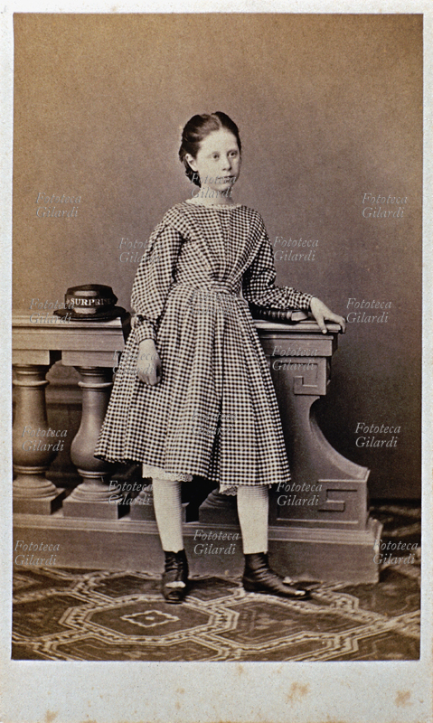 DONNA bambina a figura intera, ritratto effettuato in studio. La bimba indossa un vestito a quadrettini bianchi e neri. Dall\
