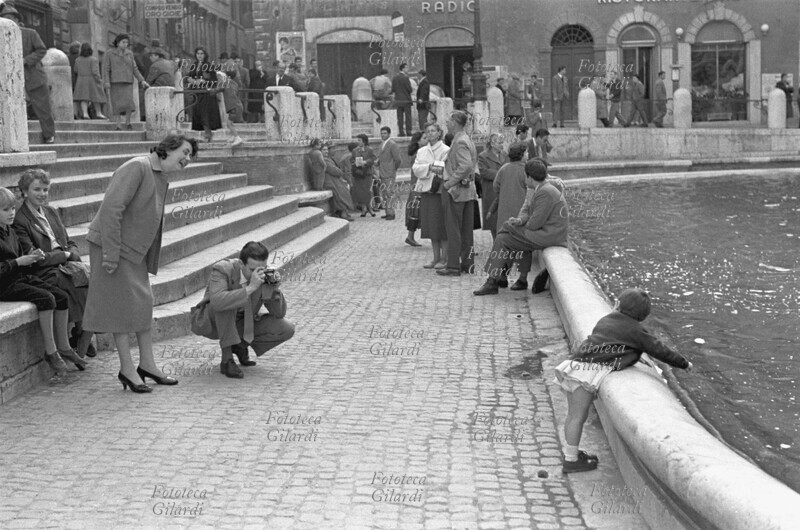 TURISMO famigliola in visita alla fontana di Trevi a Roma. I genitori fotografano la bimba mentre getta la tradizionale monetina. Fotografia di Ando Gilardi (1921 - 2012) #andogilardi, Roma 27 maggio 1956
