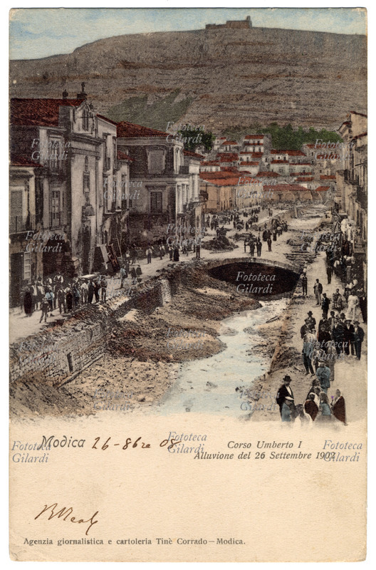 ITALY View of Corso Umberto I in Modica (RG), after the flood of September 26, 1902; postcard published by the Agency journalistic and stationery Tiné Corrado Modica. The torrent Moticano, whose bed had been covered to form the Corso Umberto I, is overflows due to the hurricane that hit the whole of Sicily, causing more than 300 casualties, including 111 in one Modica. Fotocollografia watercolor, Italy 1902