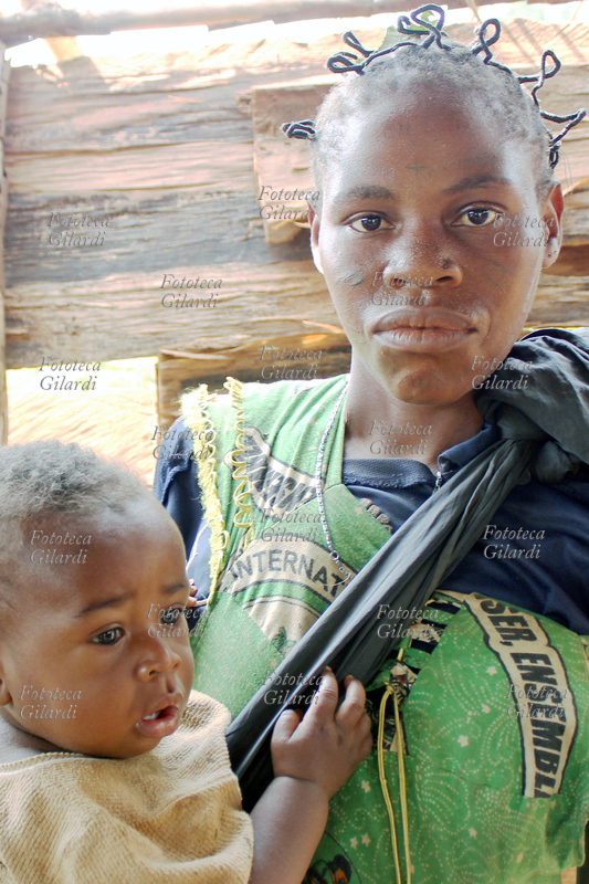AFRICA Donna della etnia Baka con bambino. Questa etnia appartiene al gruppo chiamato genericamente dei Pigmei, a causa della bassa statura che li ha fatti paragonare dai primi esploratori europei ad un leggendario popolo di nani della mitologia greca. Il termine accomuna popoli di cacciatori-raccoglitori anche molto distanti e diversi tra loro, e alcuni lo considerano discriminante se non dispregiativo. In comune hanno però lo stile di vita basato su una profonda conoscenza e rispetto dell\