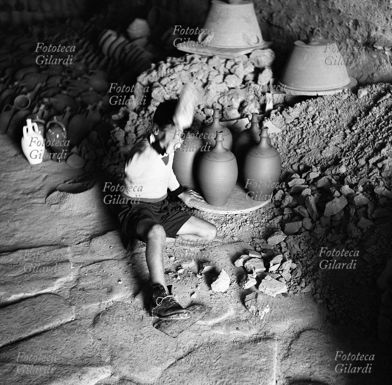 MESTIERI bambino di Grottole (MT), al lavoro in un laboratorio di produzione delle tradizionali terraglie. Il suo compito era la frantumazione dell\
