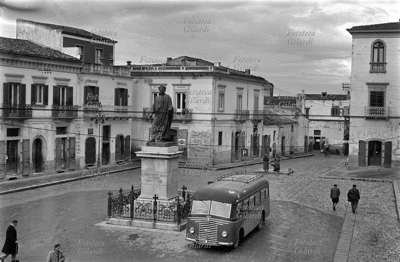 ITALIA Venosa, veduta della piazza con il monumento a Orazio. Fotografia di Ando Gilardi (1921-2012) #andogilardi, parte di un ampio servizio realizzato per \