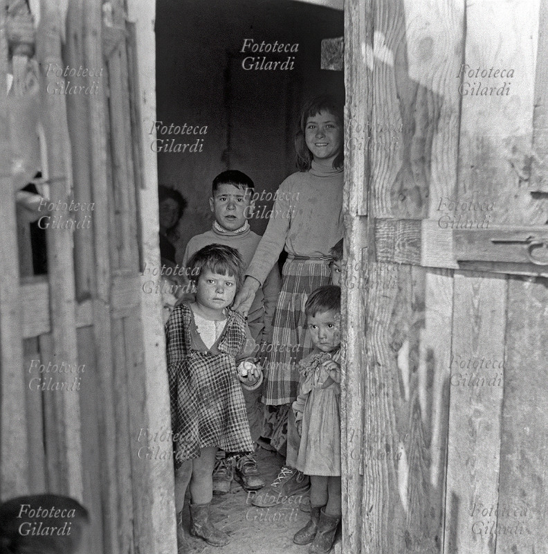 BAMBINI di età diverse, riuniti in una baracca per giocare e per studiare, scorcio sull\