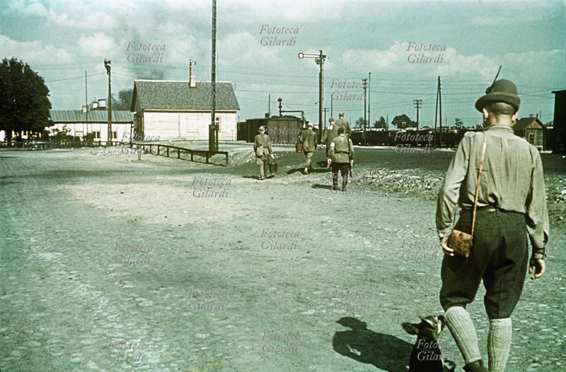 II G.M. URSS 1942. Alpini nella stazione ferroviaria di una cittadina occupata. In primo piano il Capitano Spartaco Martinengo del 3° Artiglieria Alpini. Rara testimonianza fotografica a colori di Gianfranco Ucelli (Divisione Julia, Battaglione Aquila, 3° Art. Alpini), reduce sopravvissuto alla tragica spedizione in Russia. U.R.S.S. 1942