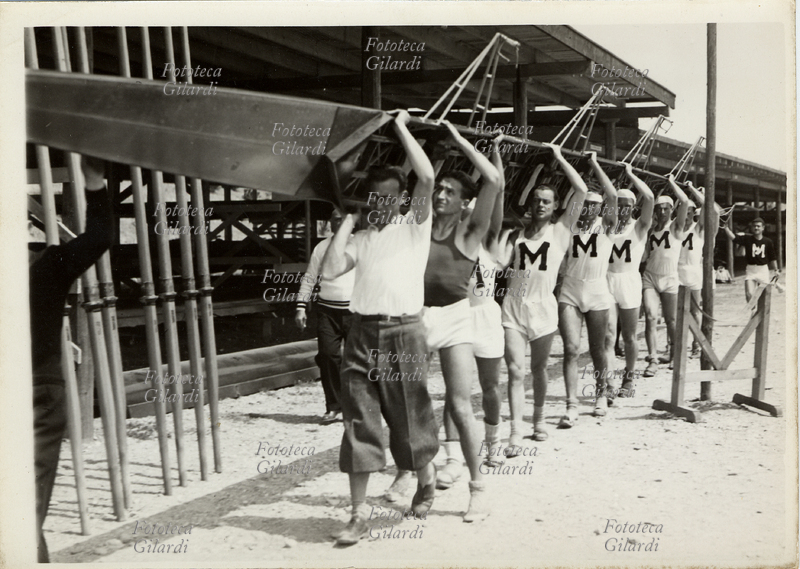 CANOTTAGGIO La squadra del G.U.F. di Milano rientra dopo la gara a otto dove si era classificata seconda. Littoriali di Milano, Idroscalo di Milano, 1936. Fotografia Argo, Milano 1936