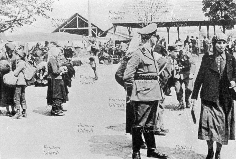 II GM JUGOSLAVIA Resistenza: deportazione delle famiglie di ostaggi fucilati. Concentramento nella piazza del mercato, i ragazzi sono separati dalle madri e inviati negli speciali istituti di denazionalizzazione \