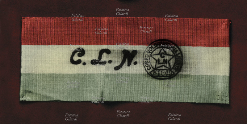 RESISTENZA Bracciale tricolore del C.L.N. Corpo Volontari per la Libertà; sulla fascia in stoffa è impresso un timbro con la sigla e un simbolo numerato. Italia 1944 circa.