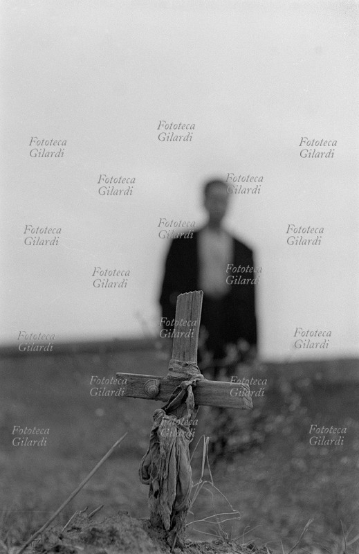 ECCIDIO DI MELISSA 29 ottobre 1949. Visita al cimitero di Melissa (Crotone) a 5 anni dalla carneficina: una delle modeste croci di legno poste sulle tombe dei braccianti uccisi. Una figura umana appare in lontananza e sfocata, accentuando la nitidezza e l\
